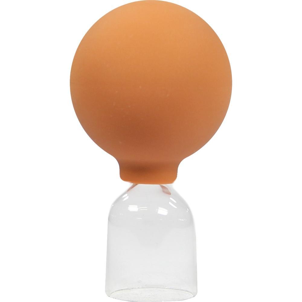 Ein oranger Gummiball sitzt auf einem durchsichtigen Glasbehälter.