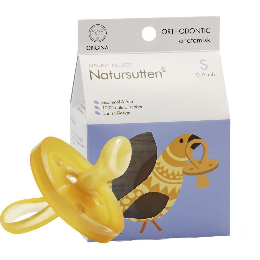 Gelber Schnuller aus nat&uuml;rlichem Gummi vor einer Verpackung mit Vogelmotiv.