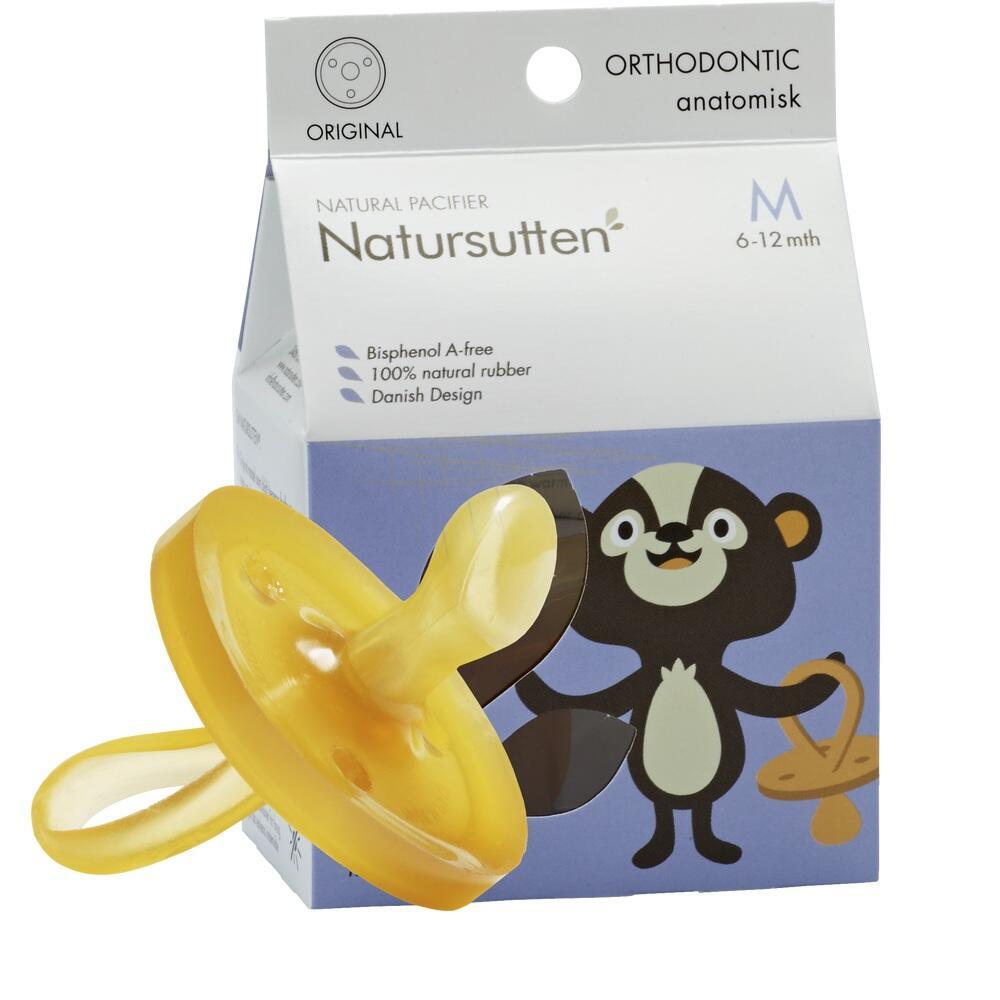 Gelber Schnuller aus Naturkautschuk vor einer Verpackung mit Tiermotiv.