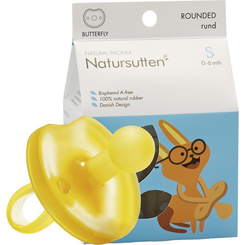 Ein gelber Babyschnuller liegt vor einer Verpackung mit Cartoon-Hase.