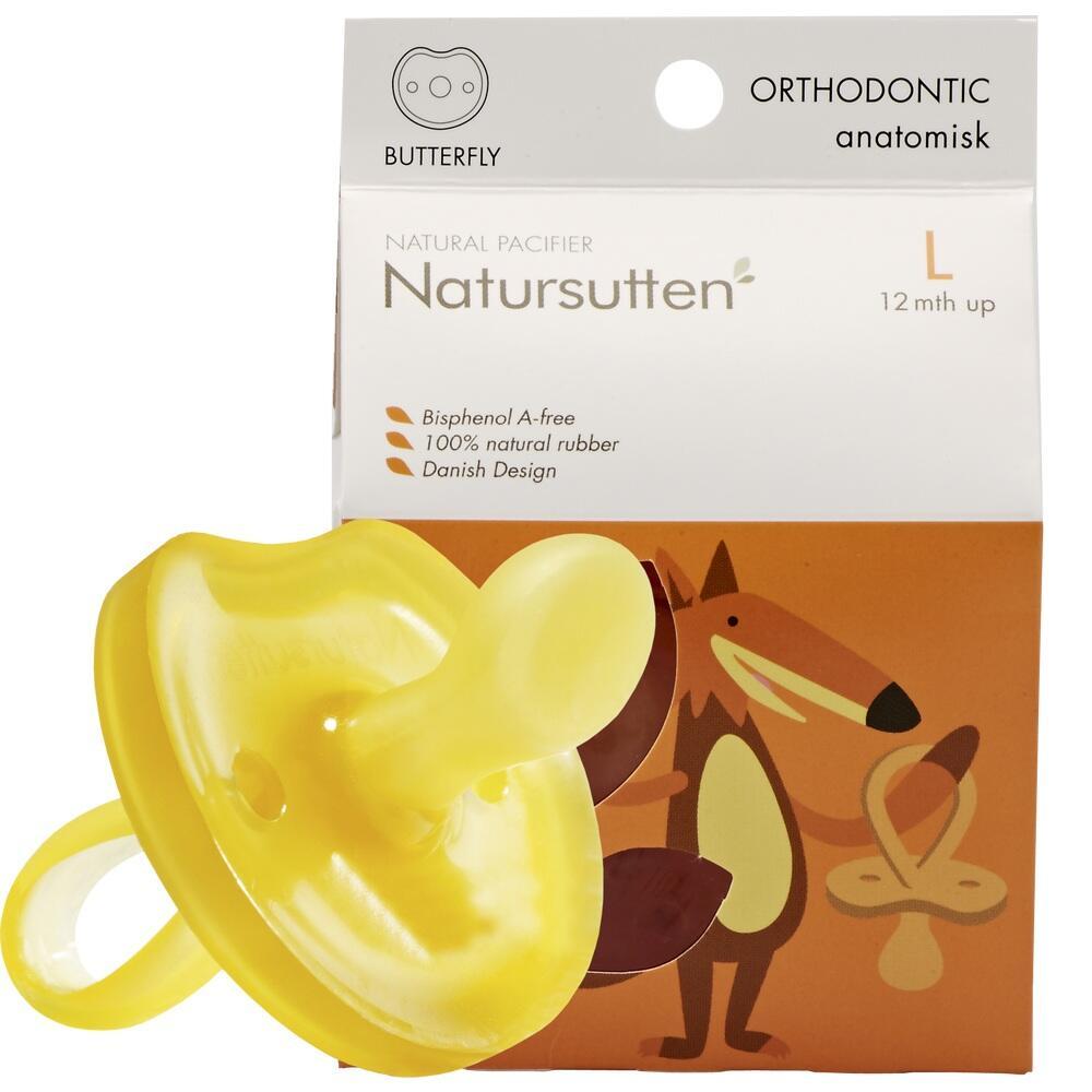 Gelber Schnuller aus Naturkautschuk vor einer orangefarbenen Verpackung.