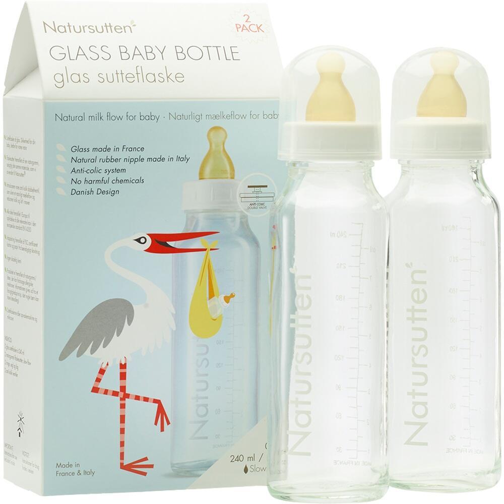 Zwei Babyflaschen aus Glas und eine Verpackung mit einem Storch darauf.
